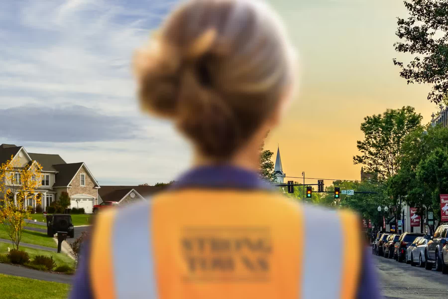 Neighbors gathering along a small-town main street lined with flags